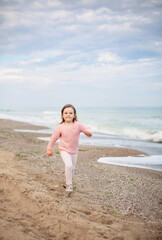 A little girl running along the seashore