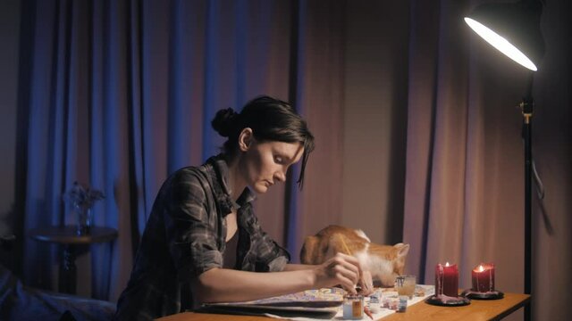 beautiful girl draws a mandala in a room with a ginger cat