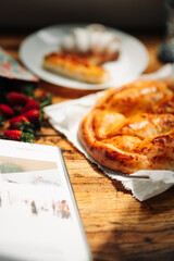 A delicious breakfast with fresh bread and strawberries lies on a wooden table