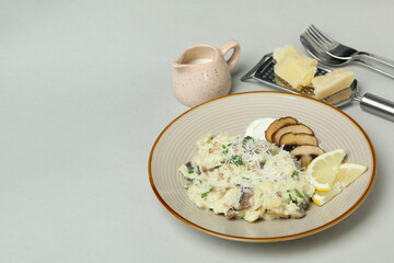 Concept of tasty food with risotto with mushrooms on light gray background