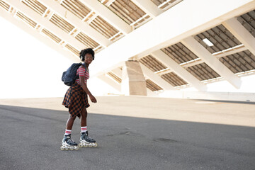 Beautiful African woman with roller skates. Urban sexy girl enjoy outdoors.