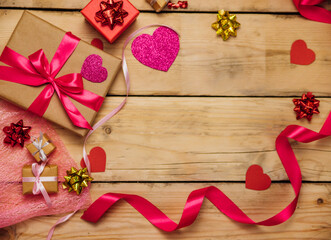 Gift boxes with satin ribbons on a wooden background. The concept of Valentine's Day, Mother's Day and Birthday.
