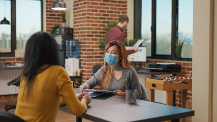 Candidate giving CV to HR consultant at job interview appointment, meeting to hire jobless person during covid 19 pandemic. Applicant and worker discussing about employment in office.