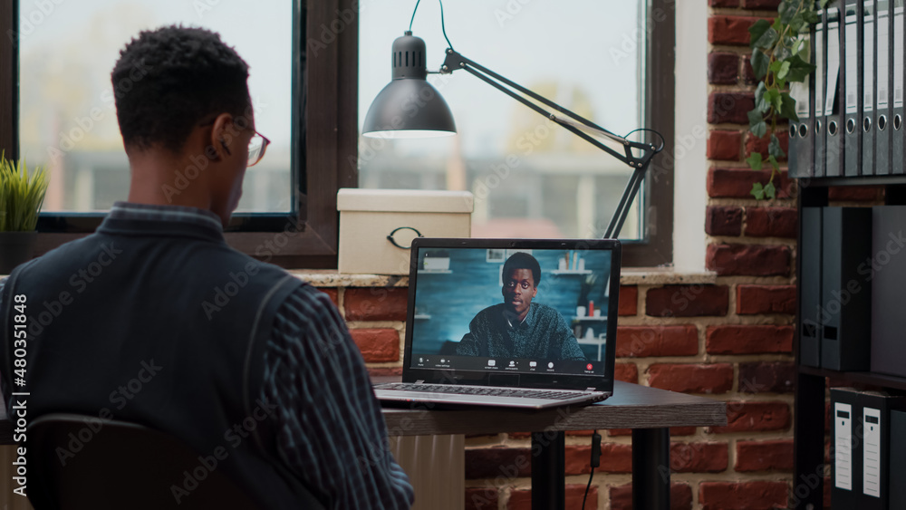 Poster Startup employee using remote video call on laptop to talk to colleague at job. Man attending business meeting with person on online videoconference for telecommunication and telework.