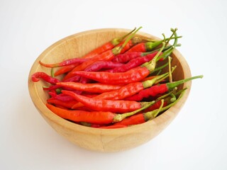 Chili pepper in wooden bowl on  white background. closeup photo, blurred.