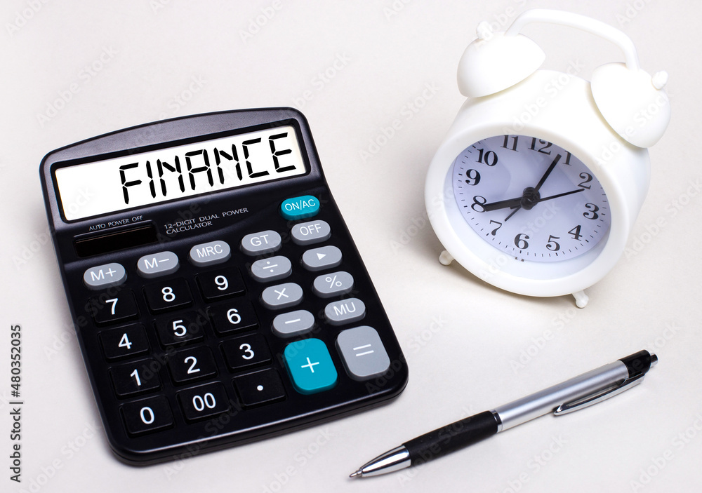 Poster on the light table there is a black calculator with the text finance on the scoreboard, a pen and a 