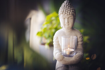 Zen spiritual ritual meditating white face of Buddha, white candle on green floral background. Religion concept, esoterics. Still life style. Home decor. Place for text, copy space.