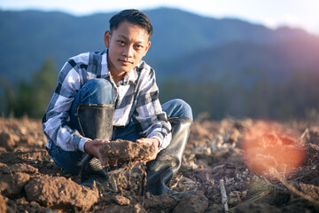 young boy farmer checks the soil in farm