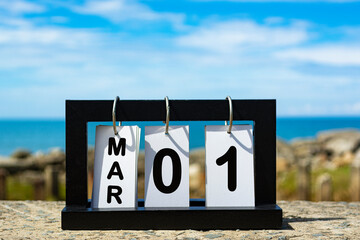 Mar 01 calendar date text on wooden frame with blurred background of ocean