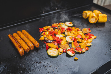 vegan barbecue with grilled vegetables plant-based sausages and corn on the cob, healthy plant-based food