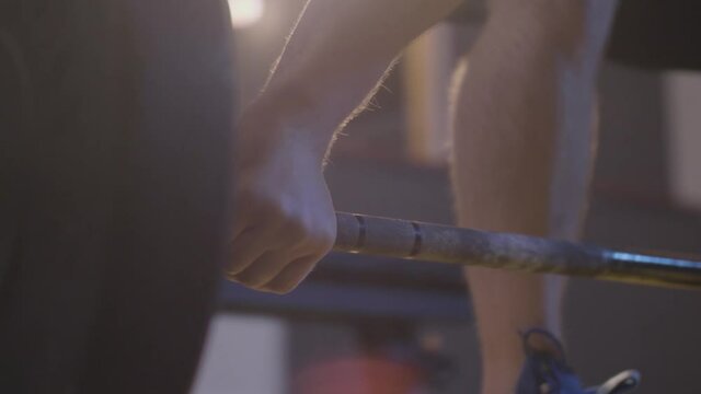 Close up detail shot of a heavy weights lifter. Caucasian man training at the gym