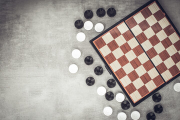 Checkers are scattered near the chessboard, top view. Mind games, mental development and strategy....