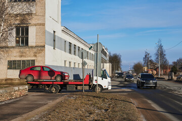 Obraz premium a tow truck takes away a red car along a city street