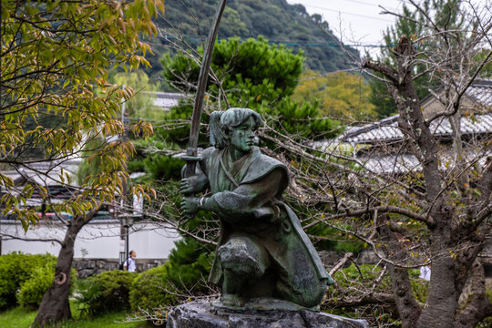 Iwakuni, Yamaguchi JAPAN - Sep 24 2020 : The famous statue of Kojiro Sasaki, a prominent Japanese swordsman (Samurai) in early Edo Period, in Kikko Park in cloudy day.