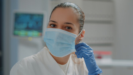 Portrait of biologist removing face mask before working in laboratory. Scientific researcher taking...