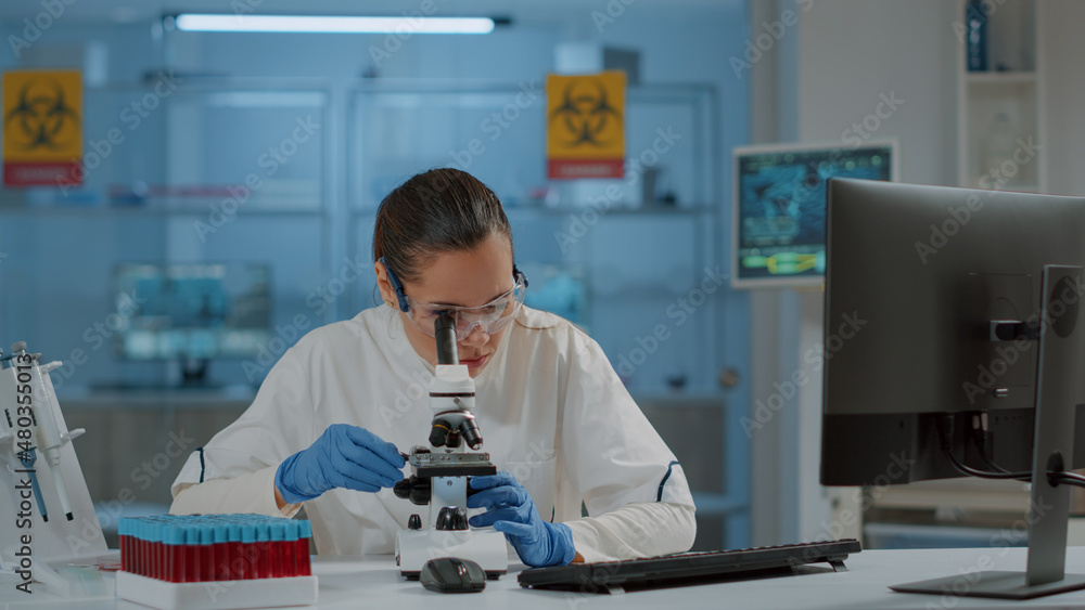 Poster lab worker using magnifying glass on microscope to work on science experiment. woman chemist analyzi