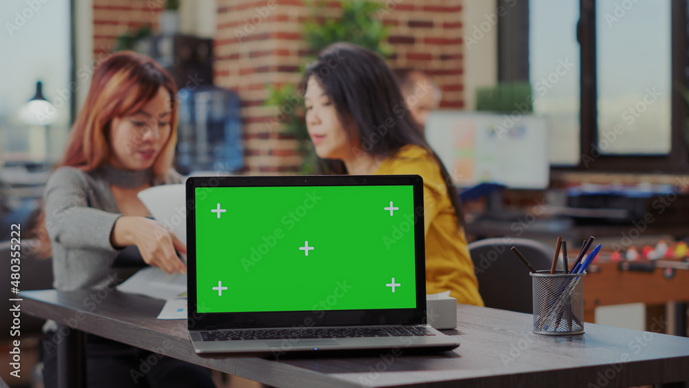 Poster laptop computer with blank green screen on business office desk. asian women working on e commerce p