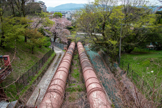 Kyoto, JAPAN - Apr 3 2021 : The water pipe line of the Keage Power Plant in cloudy day. The famous Keage Incline, a 582 meter long slope with railroad tracks, is over there