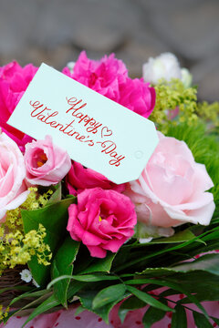 Valentine's day greeting card with flowers bouquet on wooden background. Top view with space for your greetings