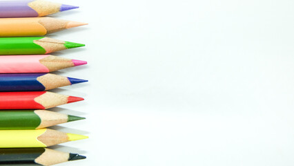 Color pencils border on white background. Isolated closeup shot with space for copy on slide.