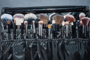 Makeup brushes on a black background, with a place to insert text,