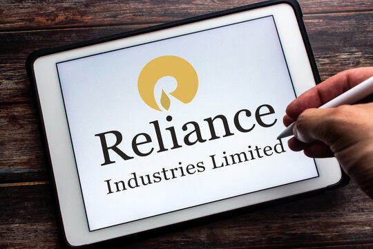 Kumamoto, JAPAN - Jul 9 2021 : Logo of Indian conglomerate Reliance Industries Limited on tablet with man hand and wireless pen. RIL is is one of the most profitable companies in India