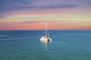 Fototapeta premium Yacht drifting on sea surface under blue cloudless sky