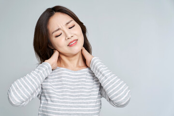 Young woman with neck pain in studio shot
