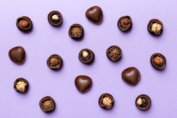 Obraz premium Different kinds of chocolates on colored table close-up. Top View and Flat Lay