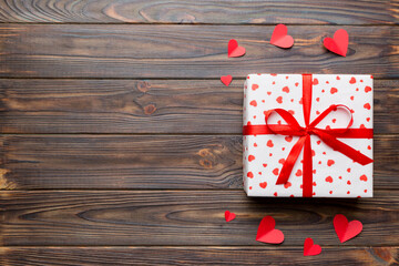 Fototapeta premium Valentine day composition: red gift box with bow and heart. Christmas present. View from above. Space for text. Holday greeting card
