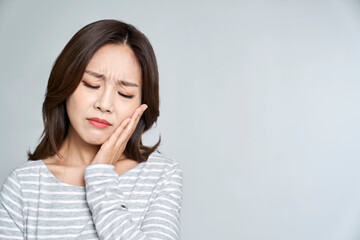 Young woman suffering from toothache with studio shot - obrazy, fototapety, plakaty