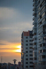 A beautiful sunset against the backdrop of a large industrial city. The rays of the setting sun are reflected in the street lamps, creating a cozy atmosphere. 