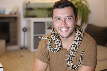 Cute man holding exotic ball python