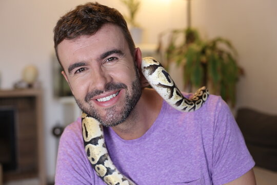 Cute man holding exotic ball python 