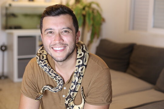 Cute man holding exotic ball python   