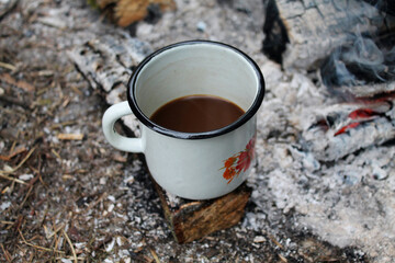 White Enamel Metal Cup with Coffee on the Ash Background