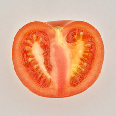 Cutted ripe tomato on the white paper background.
