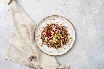 grey porcelain scandi plate with traditional east european dish buckwheat salad with butter and chickpeas on concrete surface, top view, copy space