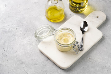 Mason jar with tasty herb butter with grated truffles on scandi plate on grey concrete surface