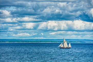 Vintage, 3 mast big sailing vessel at sea on a murky day with clouds. The old sailing ship in the...