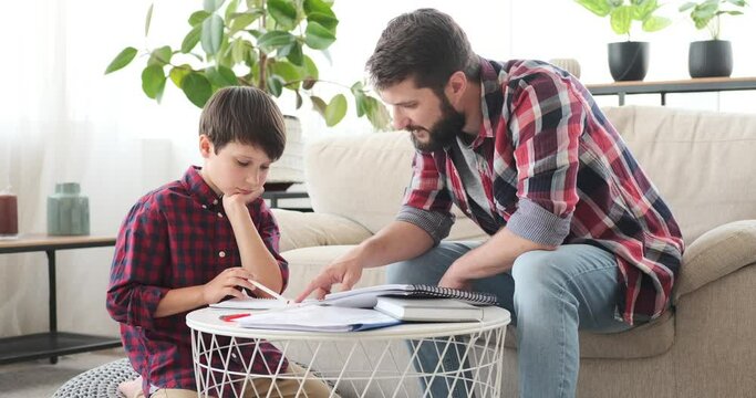 Father helping his son doing homework at home