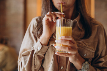 Woman drinking orange fresh in a cafe