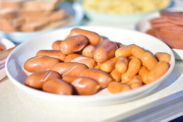 Grilled sausages on a plate ready to serve looks appetizing for a simple breakfast.