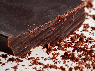 Dark chocolate pieces isolated on white background. Chocolate bar chunks, shavings and cocoa crumbs Top view.