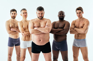 Group of multiethnic men posing for a male edition body positive beauty set. Shirtless guys with...