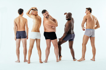 Group of multiethnic men posing for a male edition body positive beauty set. Shirtless guys with...