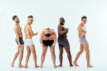 Group of multiethnic men posing for a male edition body positive beauty set. Shirtless guys with different age, and body wearing boxers underwear - obrazy, fototapety, plakaty