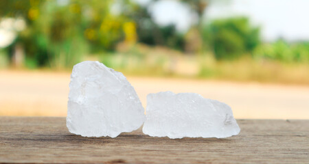 Cubes of alum on dark concrete surface and blur trees background. Soft and selective focus on alum.