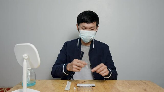 Asian man uses rapid antigen test kit to detect COVID-19 by yourself at home Preparing to test the infection of the virus will prevent the spread of the virus itself.