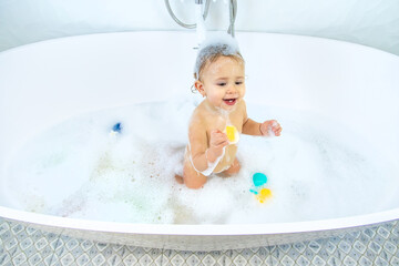 A child bathes in a bubble bath. Selective focus.